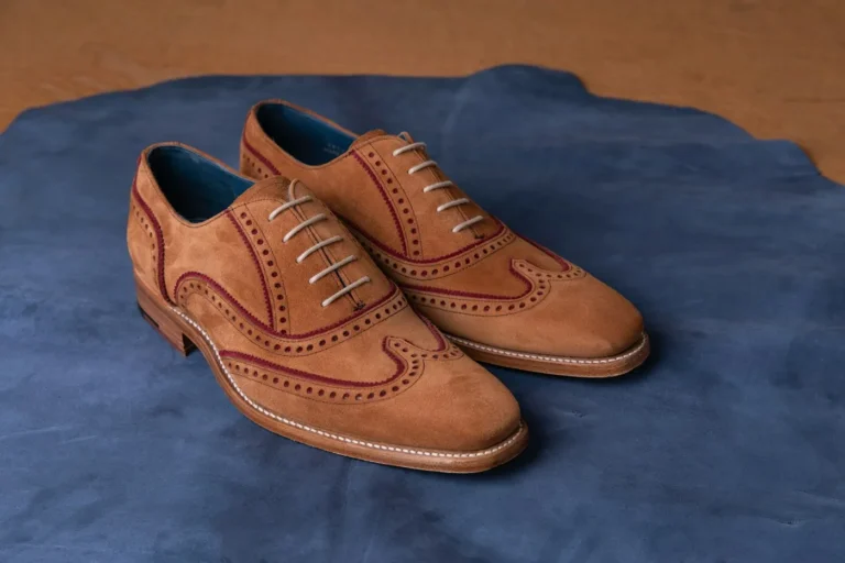 Leather shoes with perforations and visible stitching